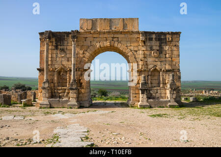 Arco di Caracalla (Arco Trionfale) presso il sito archeologico di Volubilis sotto un cielo blu, Fes-Meknes, Marocco. Foto Stock