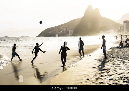 RIO DE JANEIRO, Brasile - 24 febbraio 2015: un gruppo di brasiliani giocando sulla riva della spiaggia di Ipanema, con il famoso Dois Irmaos montagna dietro di loro Foto Stock