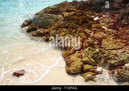 Le rocce vulcaniche in mare turchese in una spiaggia tropicale di Koh Chang Island, Thailandia. Foto Stock