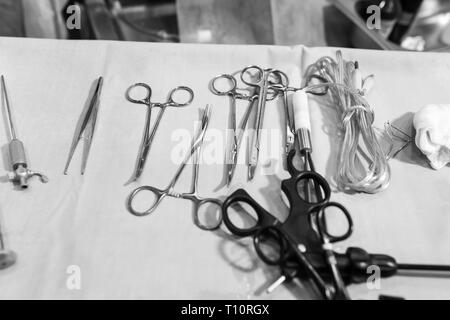 Metallo pinze chirurgiche su bianco tavolo sterile. Foto Stock