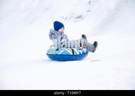 La Bielorussia, la città di Gomel, Gennaio 07, 2018.Central Park.Child slittino cheesecake.Slittino fuori una slitta da neve.Giro sul tubo. Inverno Bambini Vacanze Foto Stock