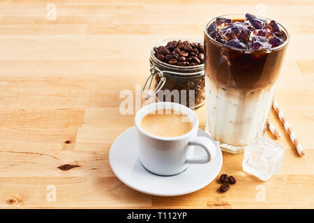 Tazza di caffè o caffè espresso, caffè ghiacciato e il latte macchiato in bicchiere con cannucce su un tavolo di legno. Vari tipi di caffè. Copia spazio per il testo. Foto Stock