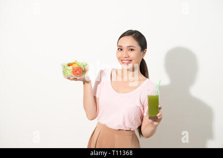 Donna con verde detox frullati, insalata in ciotola di vetro isolato su sfondo bianco. Una corretta alimentazione, cibo vegetariano, uno stile di vita sano, dieta conc Foto Stock