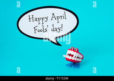 Un divertente di dentiera e il testo happy April Fools Day in un discorso di palloncino, su uno sfondo blu Foto Stock