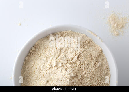 La quinoa farina nella ciotola bianco su sfondo bianco, closeup, vista dall'alto Foto Stock