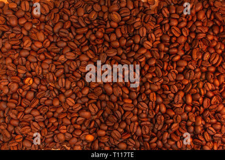Chicchi di caffè tostati sfondo. Aroma caffeina bere ingrediente per bevanda al caffè. Close-up texture saturo. Foto Stock
