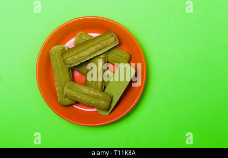 Tè verde Matcha biscotti aromatizzati su sfondo colorato Foto Stock