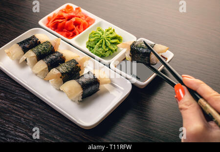 Donna di immersione a mano sushi in salsa di soia Foto Stock