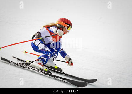 Giovane sciatore in azione in slalom competizione di sci in discesa Foto Stock