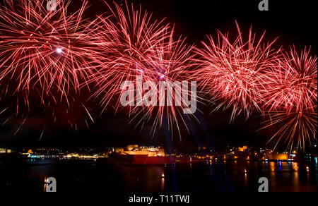 Spettacolo di fuochi d'artificio,coloratissimi fuochi d'artificio sul cielo nero sfondo, fuochi d'artificio esplosione nel cielo scuro con city silouthe sul fondo, fuochi d'artificio a Malta Foto Stock