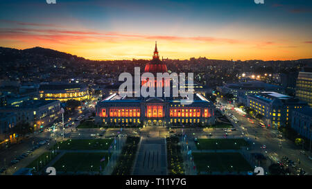 Antenna vista panoramica della città di San Francisco Hall al tramonto con le luci della città Foto Stock