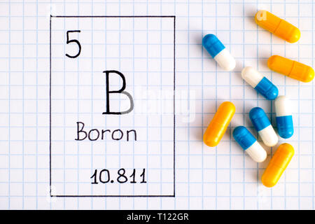 La grafia elemento chimico boro B con alcune pillole. Close-up. Foto Stock