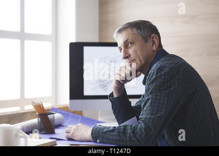 Ingegnere carpenter lavorando su laptop e schizzi di progetto Foto Stock