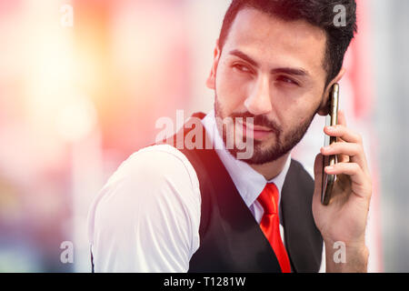 Hipster imprenditore rendendo chiamata telefonica in attesa del contatto aziendale. Foto Stock