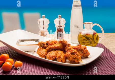 Frittelle di pollo preparato con farina di mais, fritti in olio, servito con patate e salse. Foto Stock