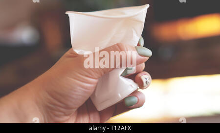 Mani break piatti di plastica, divieto di persone e di smettere di utilizzare i rifiuti che contengono materie plastiche. Concetto di riciclaggio di plastica e di ecologia - sfondo sfocato Foto Stock