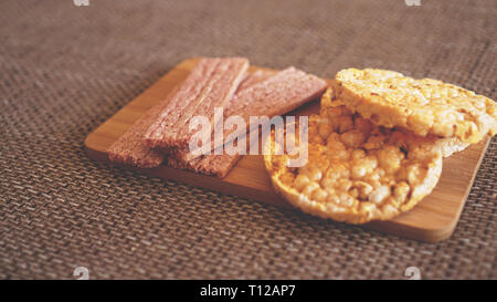 Composizione con croccante di torte di riso su sfondo di legno, vista laterale - soft focus, cibo sano Foto Stock