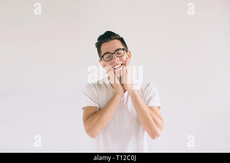Uomo in bianco t-shirt e occhiali con un grande sorriso isolati su sfondo bianco. Una molto gentile studente ha un buon umore. Foto Stock