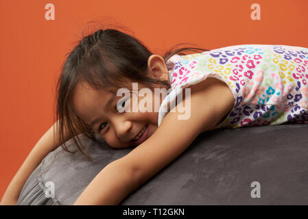 Asian kid relax su una beanbag. Filipina kid. Foto Stock