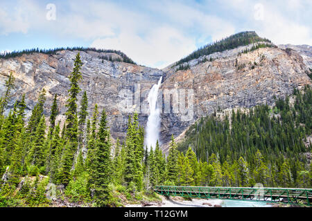 Il Footbridge attraverso Fiume Kicking Horse alla potente delle Cascate di Takakkaw nel Parco Nazionale di Yoho vicino campo, British Columbia, Canada. Il Ghiacciaio-nutriti ad acqua Foto Stock