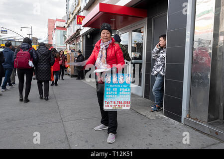 Una donna su Main st. nelle mani di Chinatown in lingua cinese dei volantini per Selectravel & Tour. In lavaggio, Queens, a New York City. Foto Stock