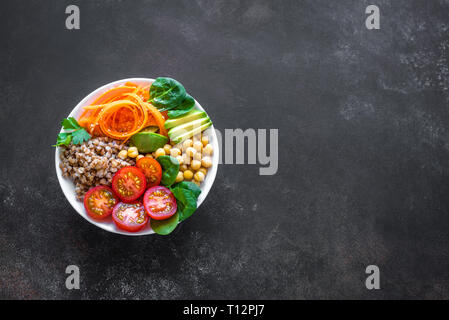 Ciotola di Buddha con insalata di grano saraceno, avocado, carote, pomodoro, spinaci, ceci. Vegetariano sana dieta vegana mangiare, super cibo. Vista superiore, copia dello spazio. Foto Stock