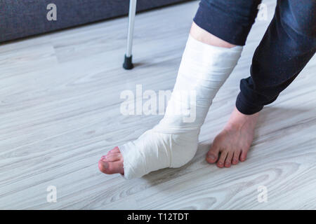 Camminare sulle stampelle con una gamba in un cast Foto Stock