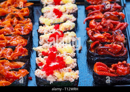 Rotoli di sushi giapponese di delicatezza. Il giapponese del cibo tradizionale a base di riso e pesce o frutti di mare. Una serie di deliziose prelibatezze in un mercato di giorno in Tailandia, Foto Stock