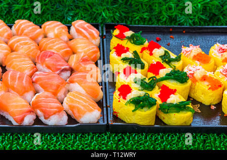 Rotoli di sushi giapponese di delicatezza. Il giapponese del cibo tradizionale a base di riso e pesce o frutti di mare. Una serie di deliziose prelibatezze in un mercato di giorno in Tailandia, Foto Stock