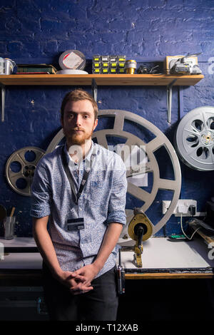 Un lavoratore di sesso maschile in Brighton Duke of York's Picture House Cinema di taglio / sala di proiezione Foto Stock