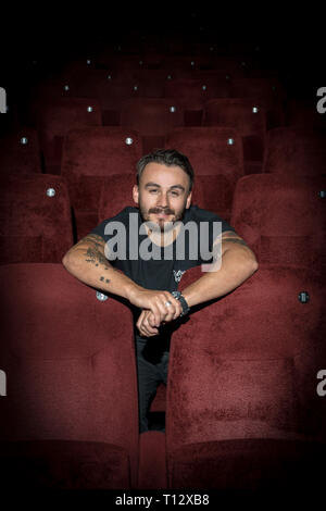 Un elemento maschio di personale si siede in un auditorium vuoto del Duca di Yorks movie theater in Brighton Foto Stock