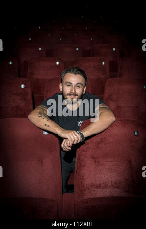 Un elemento maschio di personale si siede in un auditorium vuoto del Duca di Yorks movie theater in Brighton Foto Stock