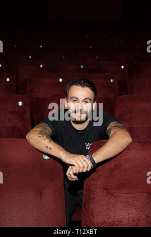 Un elemento maschio di personale si siede in un auditorium vuoto del Duca di Yorks movie theater in Brighton Foto Stock