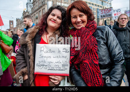 Due donne sono visti tenendo un cartello durante la dimostrazione. Migliaia di persone si sono radunate a Dam Square nel centro di Amsterdam a dimostrare contro il razzismo e la discriminazione. Essi chiedono la diversità e la solidarietà, contro tutte le forme di razzismo e di discriminazione. Inoltre, contro i due politici di estrema destra parti nei Paesi Bassi, il PVV e la FvD che hanno aumentato la loro potenza durante le ultime elezioni nel paese. Un piccolo gruppo di estrema destra ha mostrato durante il cammino tenendo due grandi cartelli e grida di manifestanti. Foto Stock