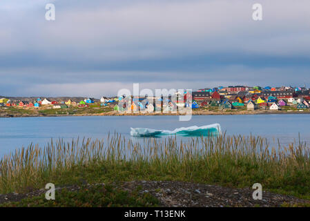 Iceberg galleggianti, spiaggia nera e luminosamente case dipinte, Qeqertarsuaq, Groenlandia Foto Stock