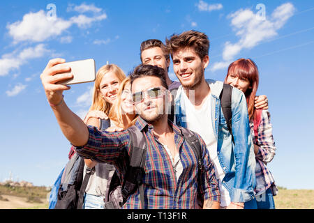 Gruppo di amici prendendo un autoritratto outdoor Foto Stock