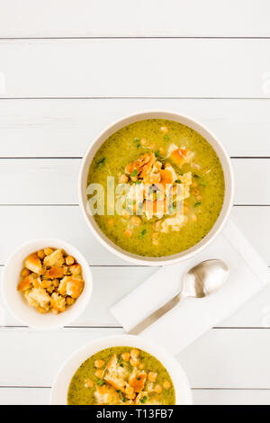 In casa di broccoli e la zuppa di ceci con un condimento di cotta al forno a ciabatta pane grattugiato mescolato con parmigiano e decorate con il crescione. Vista dall'alto. Foto Stock