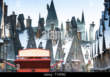 Vista del paesaggio di Hogsmeade, Il mondo di Wizarding di Harry Potter con un colore rosso brillante Butterbeer stand di vendita in primo piano. N. persone in scena. Foto Stock
