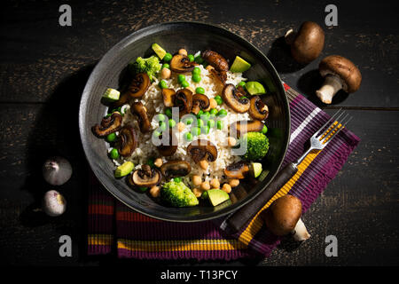 Piatto vegano: naturale riso con champignon, piselli, ceci, avocado e broccoli Foto Stock