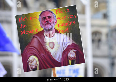 Londra, Regno Unito. Il 23 marzo 2019. Un segno raffigurante leader laburista Jeremy Corbyn come il Messia è tenuto aloft come migliaia di persone partecipano in un rally in piazza del Parlamento dopo il 'metterlo al popolo marzo", su cosa doveva essere di sei giorni prima che il Regno Unito era dovuto a lasciare l'UE, prima di una proroga per la data di partenza è stato dato. I dimostranti chiedono che il pubblico è dato un ultima parola su Brexit come supporto per il primo ministro del piano di ritiro continua a retrocedere. Credito: Stephen Chung / Alamy Live News Foto Stock