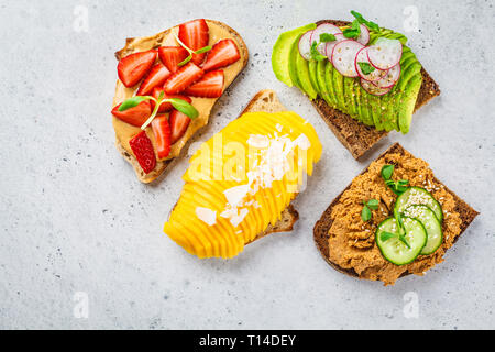 Vegane panini con mango, fragola, tofu pate, avocado su uno sfondo bianco. Foto Stock