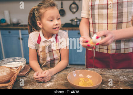 La cottura di torte fatte in casa. Felice famiglia amorevole sono la preparazione di prodotti da forno insieme. La madre e il bambino figlia ragazza di cottura sono i cookie e divertirsi la ki Foto Stock