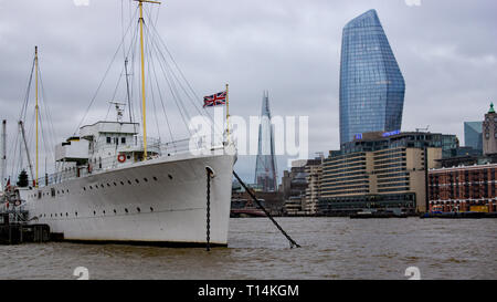 HQS Wellington ormeggiato sul terrapieno, il lato nord del Tamigi con il Coccio e Blackfriars edifici in background. Foto Stock