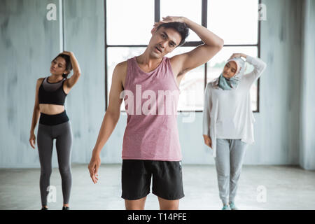 Un gruppo di persone in fase di riscaldamento prima di fare ginnastica core Foto Stock