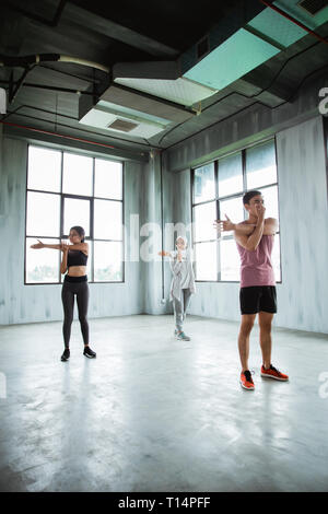 Un gruppo di persone in fase di riscaldamento prima di fare ginnastica core Foto Stock