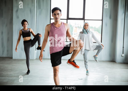Un gruppo di persone in fase di riscaldamento prima di fare ginnastica core Foto Stock