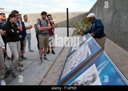 I turisti di ascoltare un ex prigioniero, ora una guida turistica, nel cortile della prigione di Robben Island, dove Nelson Mandela fu imprigionato durante l apartheid, Cap Foto Stock