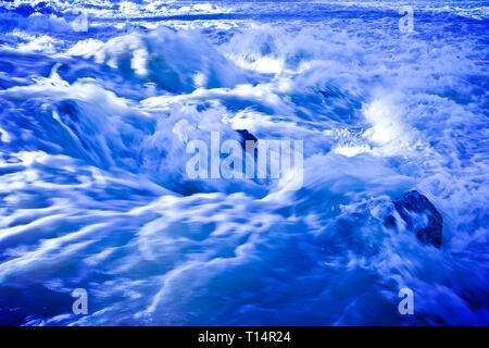 Impetuose acque di un fiume gonfi durante la stagione delle piogge - immagine dai toni Foto Stock