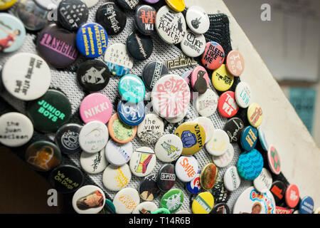 Un sacco di badge rotondo su una scala in un negozio di record Foto Stock