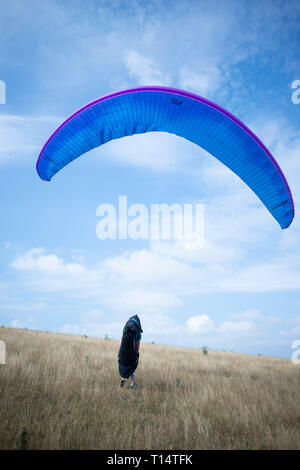 Un giovane femmina para parapendio decolla dal South Downs. Foto Stock